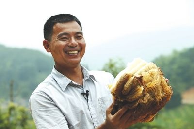 梁野仙蜜養(yǎng)蜂專業(yè)合作社理事長(zhǎng)鐘亮生在展示養(yǎng)殖的百花蜂蜜。