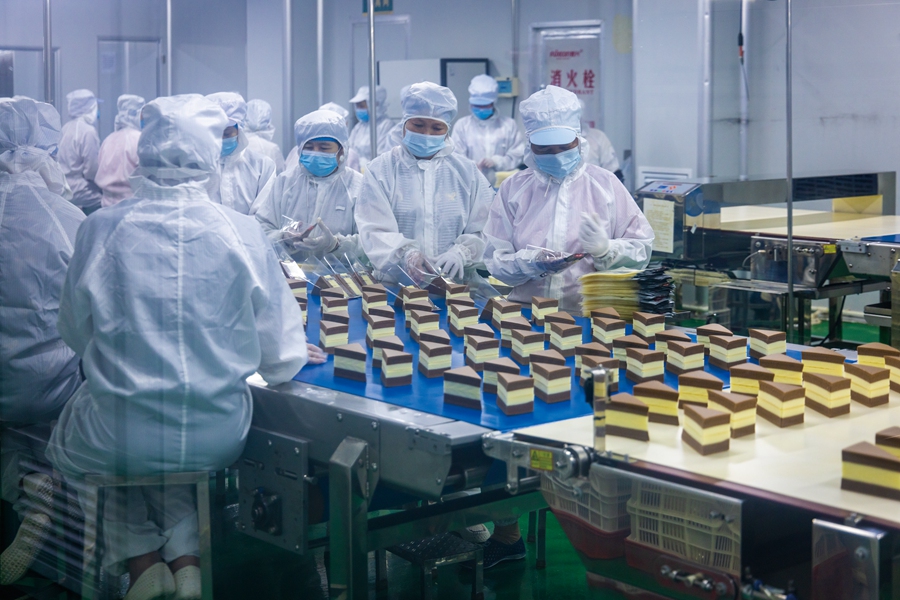 8月25日，在福建省漳州市龍海區(qū)一家食品企業(yè)，工人們忙著包裝糕點(diǎn)。楊輝潛攝