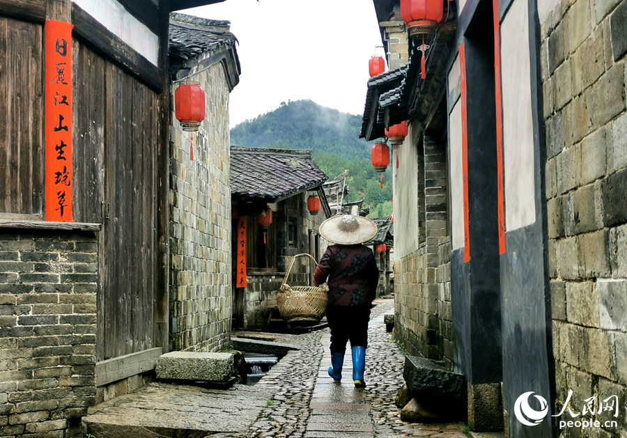 一位勞作后的村民走在青石板路上。人民網(wǎng) 林曉麗攝