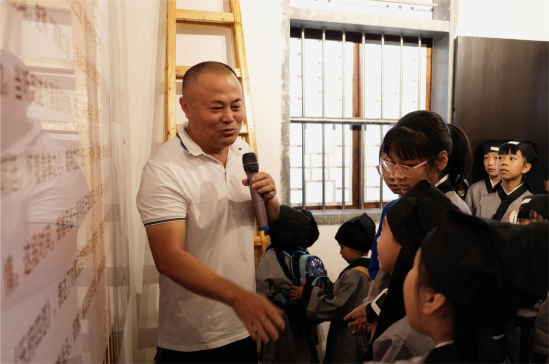 魏祖選為參加研學(xué)活動(dòng)的孩子們講解廣山村文化。來(lái)源：涵江區(qū)融媒體中心